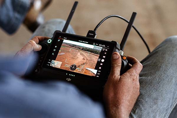 Looking over the shoulder of a man using technology to observe his land
