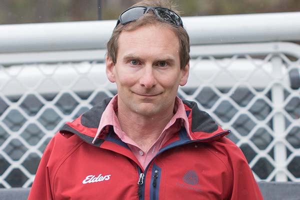 Close-up of Adam Hancock standing at back of a ute